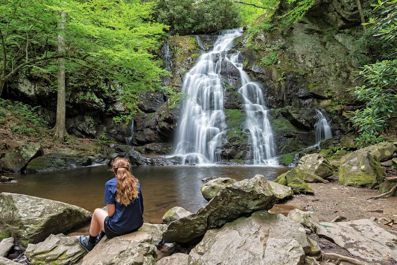 Woman sitting in front a waterfall in the Smoky Mountains
