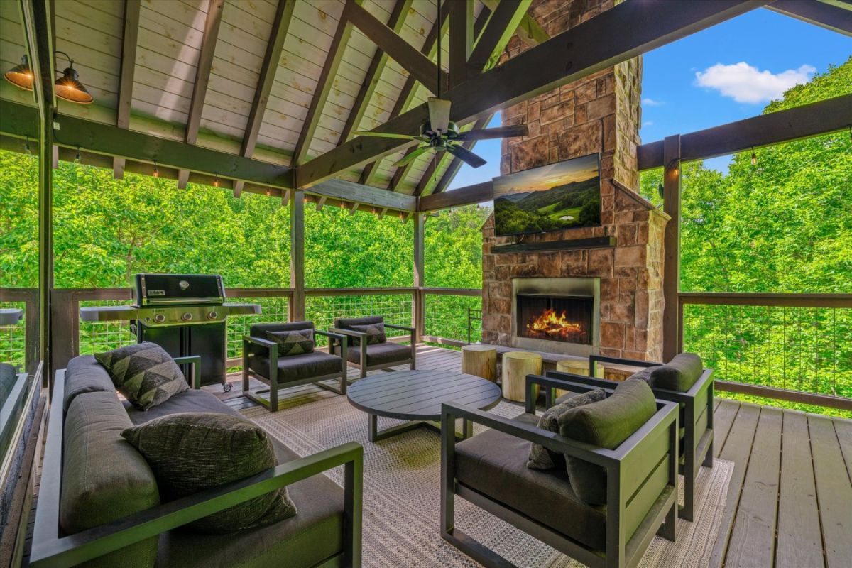 Covered porch with fireplace at a luxury Smoky Mountain cabin rental